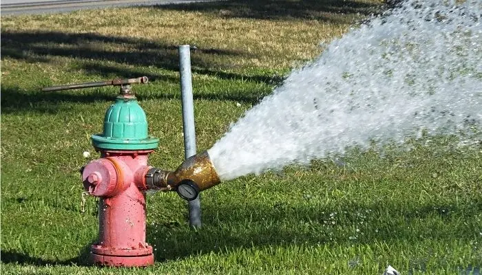 Private fire hydrant being flushed and flow tested during an inspection to check that it opens, flows, and drains properly